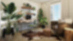 A cozy home office with a desk, laptop, and green chair. Plants and shelves with decor on walls. Soft light from a window with curtains.