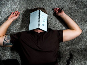 Overwhelmed by life's demands, a father lies on the floor, notebook open on his face, symbolizing his constant struggle to start anew.