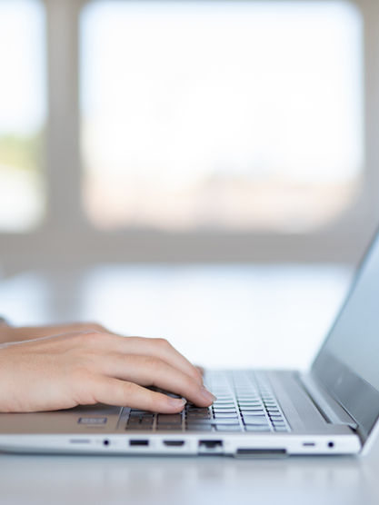 Students hands typing on a laptop.