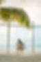 Couple sitting on a beach swing facing the ocean, symbolizing peace of mind through real estate guidance