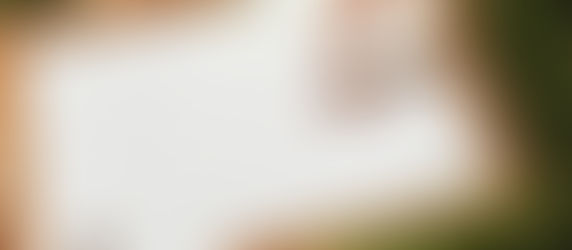 uno specchio con cornice dorata su un prato e mani che si riflettono