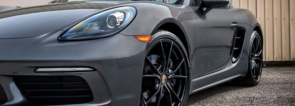 Gray Porsche in front of garage