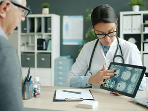 Médica mostrando resultado de exame de imagem ao paciente