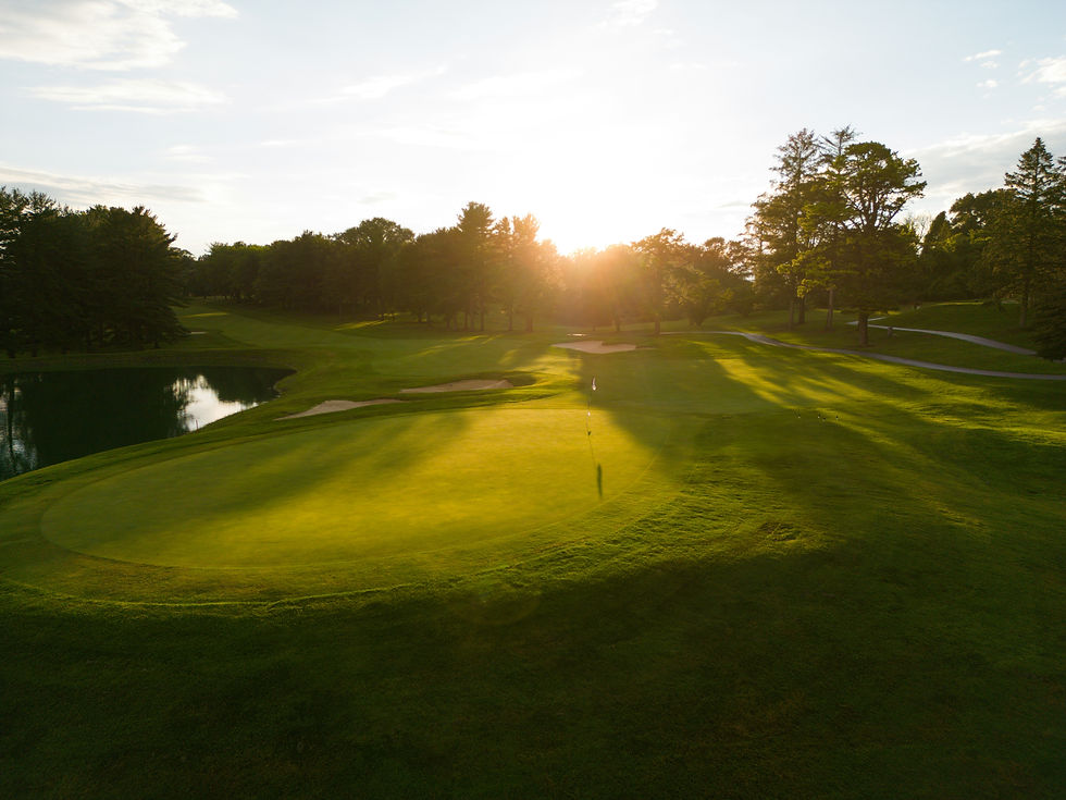 Wide angle view of a golf course tee with the sun shining