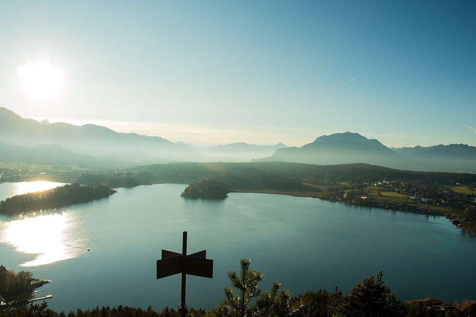 Wide-angle view of a clear Carinthian lake with mountains in the background.