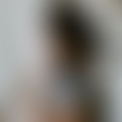 A woman cuddles a swaddled baby in a star-patterned blanket. The setting is a nursery with a map on the wall, conveying warmth and tenderness.