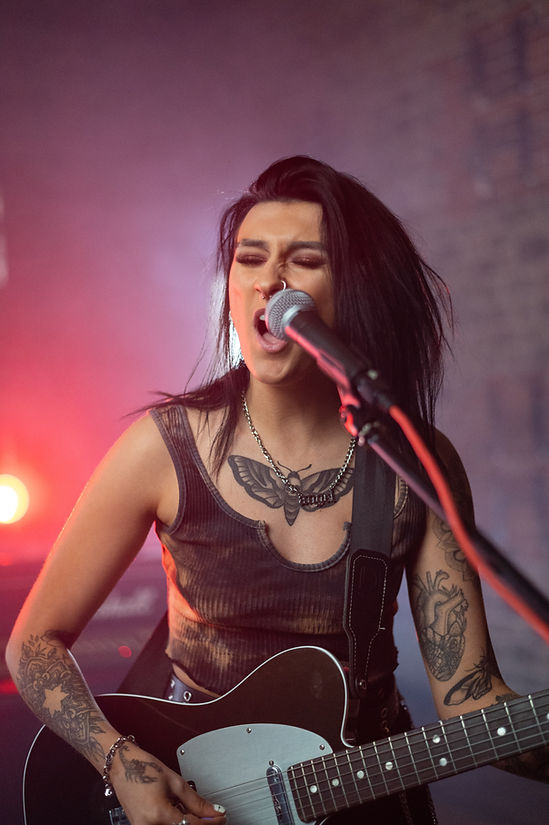 Image by Harry Shelton woman singing with microphone playing guitar