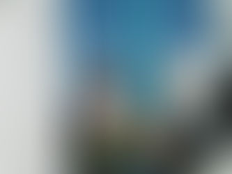 A woman sitting with sunglasses on outside wearing a backpack