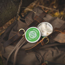 Round pouch container resting on a bag outdoors