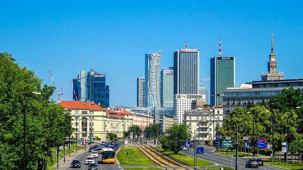 High-rise residential buildings with glass balconies stretch upwards against a clear sky, creating a symmetrical, urban cityscape view.