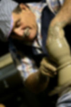 potter forming clay into vase on potter's wheel