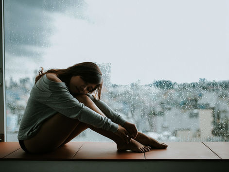 Maladies auto-immunes chez la femme : fatigue chronique et symptômes invisibles, femme près d’une fenêtre