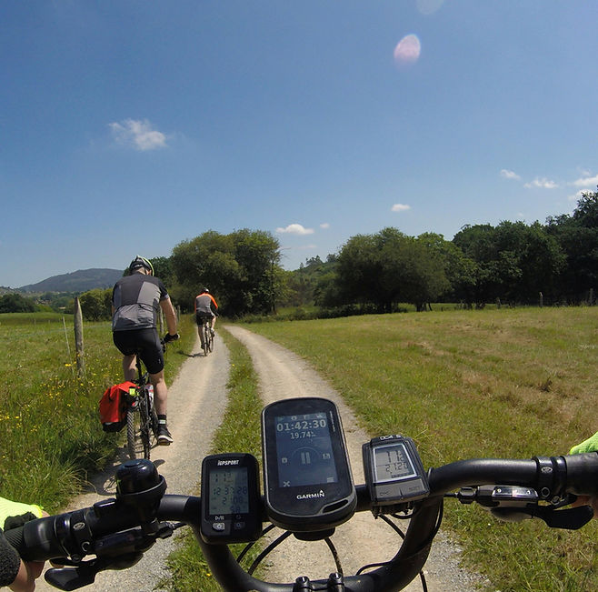 Radfahrer auf Feldweg fahren, sonniger Tag, Fahrradhelm, Fahrradhose, Regenjacke.