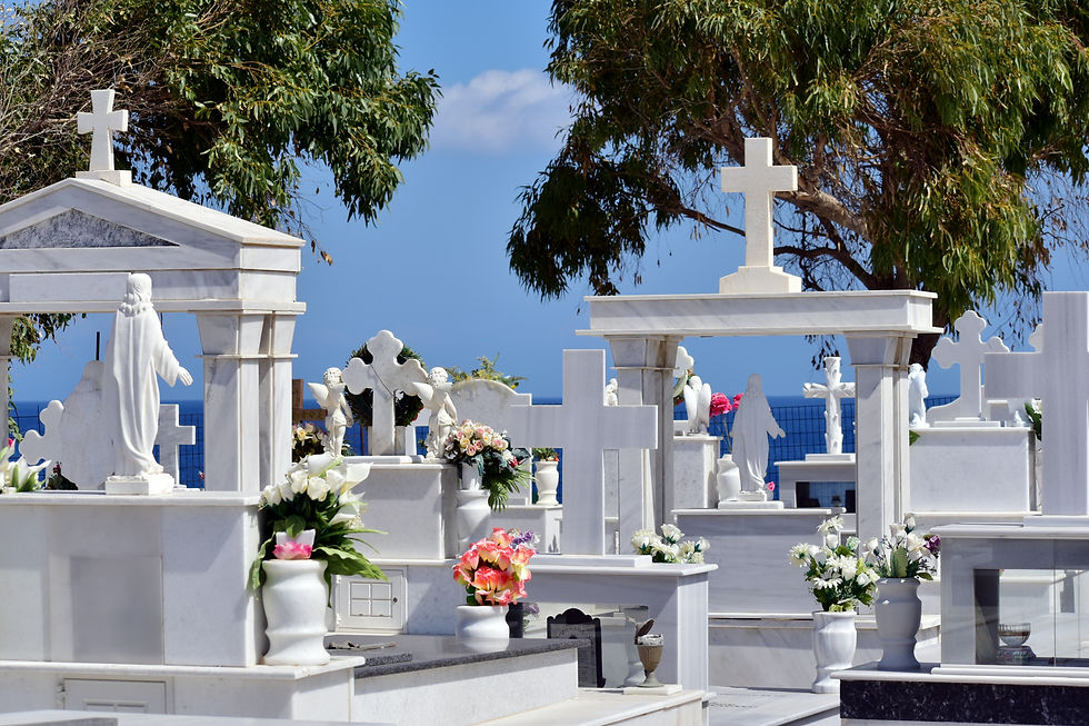 Lápida con forma de cruz y corona de flores en el cementerio durante una emotiva ceremonia fúnebre conmemorativa.