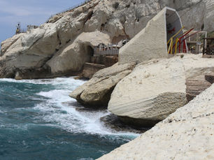 White limestone cliffs and crashing Mediterranean waves at Rosh Hanikra tourist site with accessible pathways in Northern Israel.