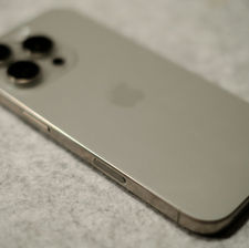 iPhone haut de gamme posé sur surface grise – Modèle récent avec triple capteur photo et finition aluminium élégante