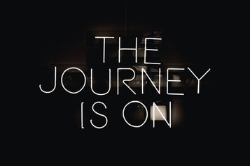 Fekete háttéren fehér neon felirat: THE JOURNEY IS ON, modern, hangulatos poszter.