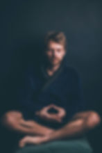 Man sits quietly on a pillow meditating and practicing mindfulness