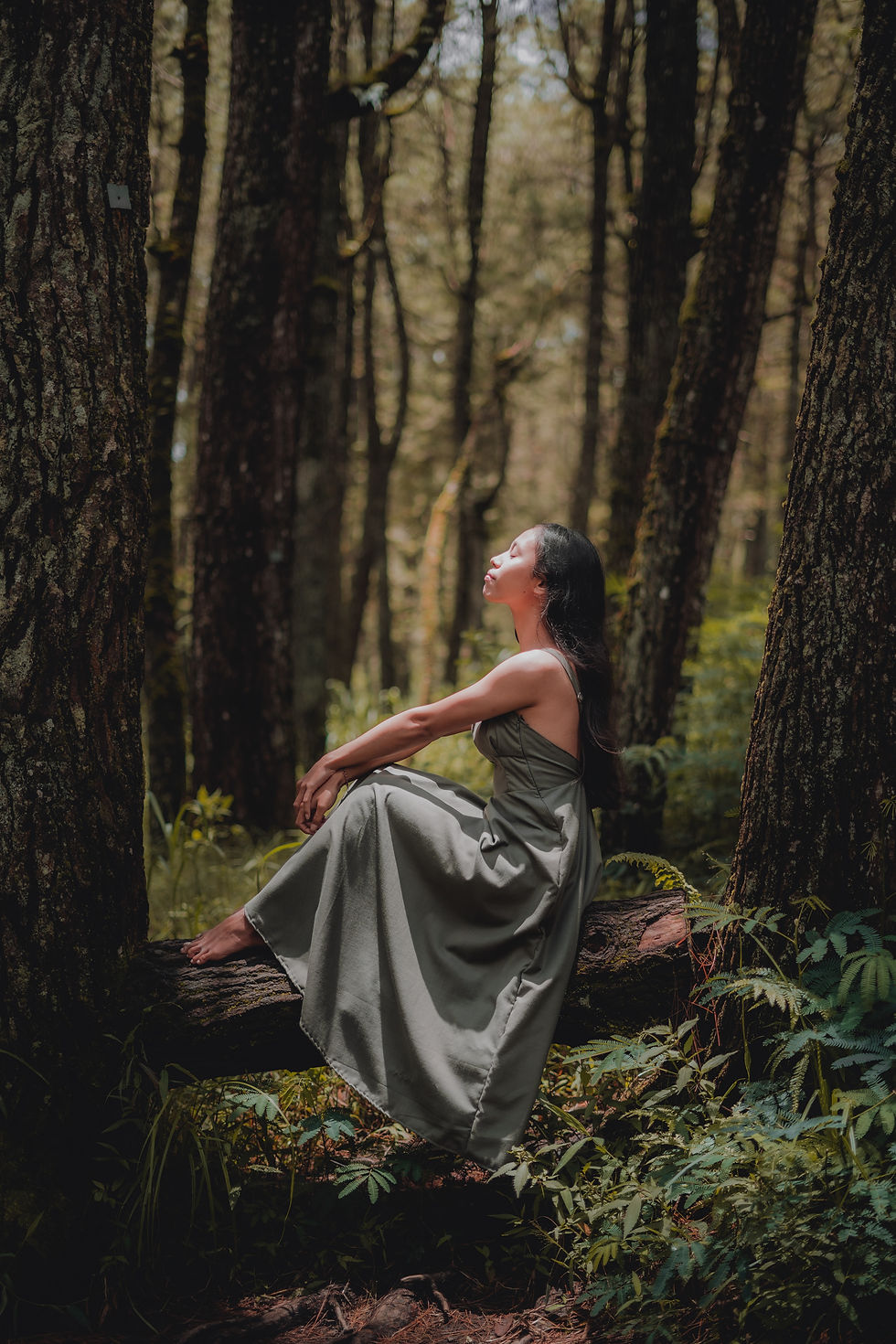 a woman wearing sustainable clothes sitting in a forest