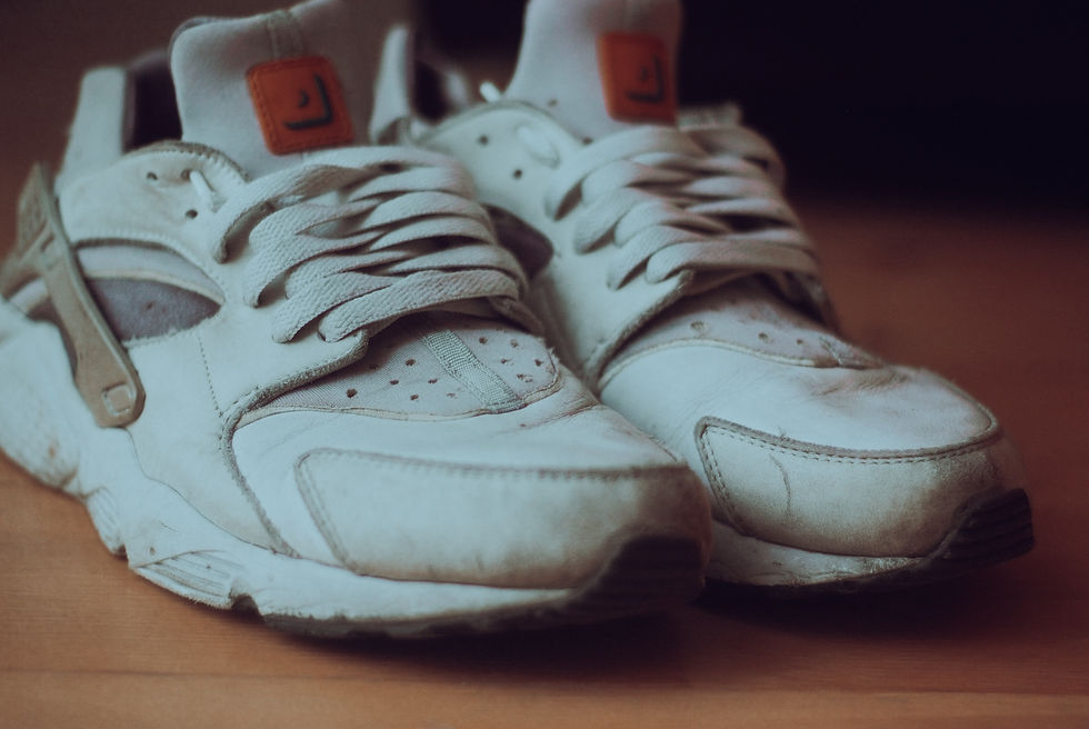 Close-up view of worn sneakers on a wooden floor