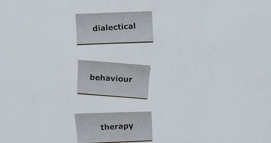 Abbie Anderson provides DBT. Picture is of 3 pieces of paper that say dialectical behavior therapy.