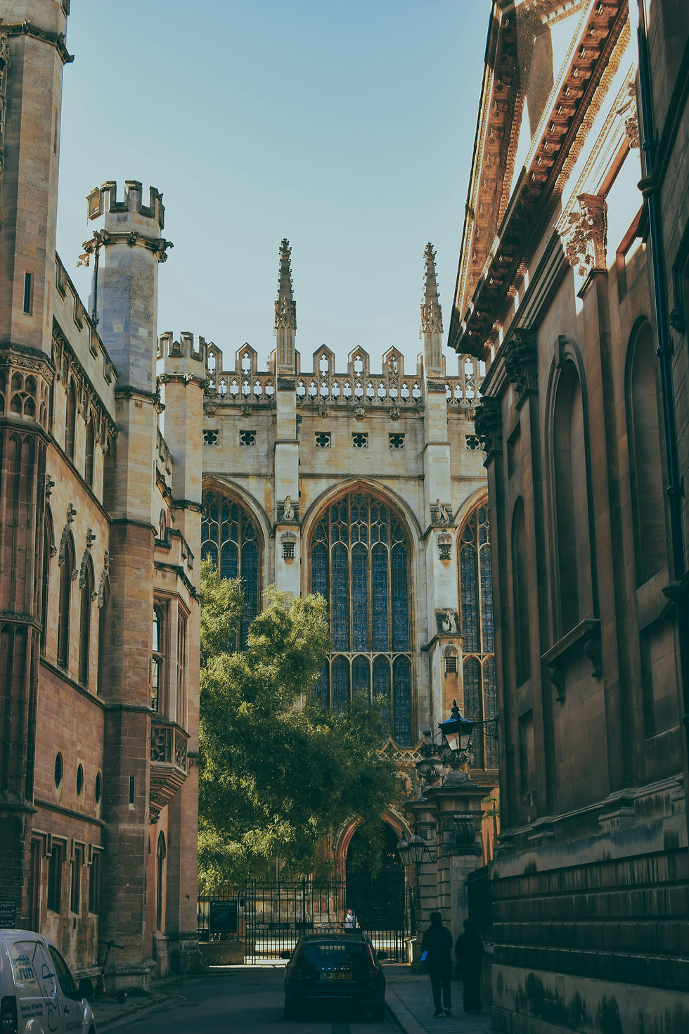 Eye-level view of historic Cambridge college buildings along a cobbled street