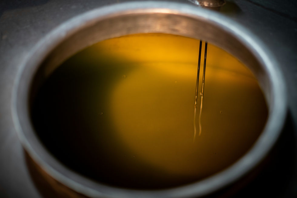 Warm liquid ghee in a traditional copper bowl for oiling the naval.