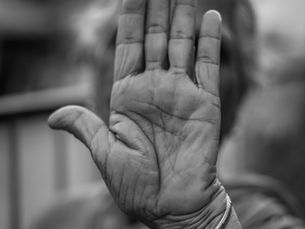 Una donna anziana si copre il volto con la mano