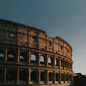 The Colosseum under a clear sky with text "Which Traveller Are You?" in bold, light-colored letters, evoking a sense of adventure.