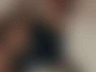 A lady sitting by her bed smoking a cigerette