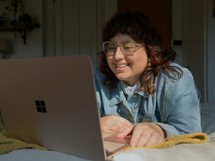 Woman Smiling at Laptop Screen | Clinical Supervision | Her Time Therapy | Virtual Supervision