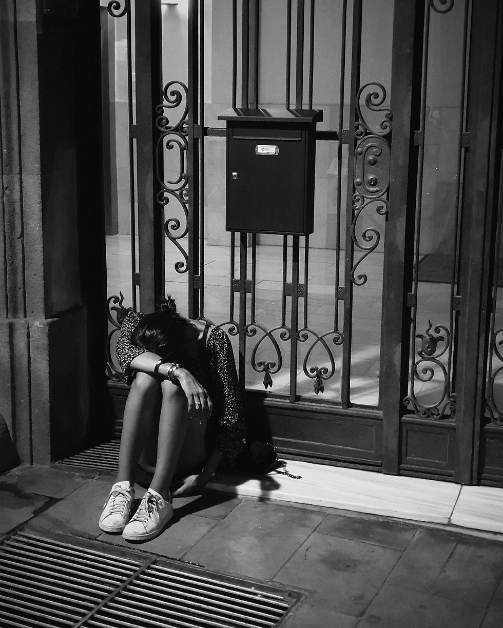 A sad woman sitting on a doorstep