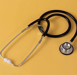 stethoscope laid in front of yellow background