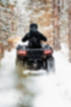atv riding through winter forest trails