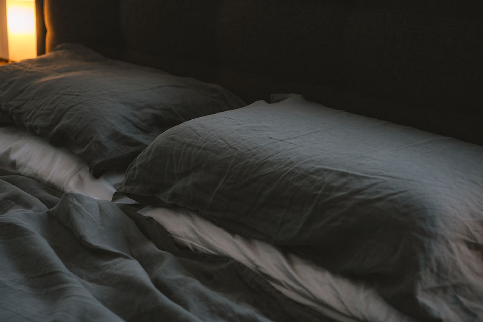 Man peacefully sleeping in bed under warm light.