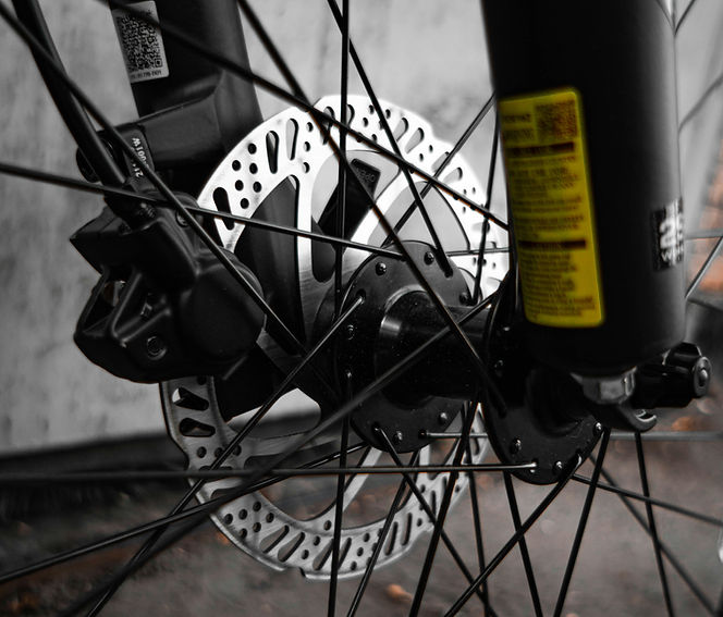 Fahrradrad mit Scheibenbremse, Detailaufnahme. Gelbes Etikett am Gabel Detailaufnahme Fahrradbremsen.