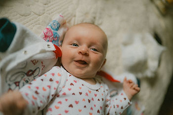 A baby enjoying the present moment and smiling.