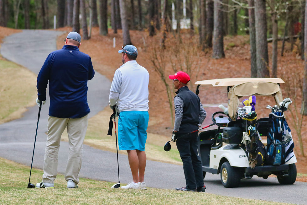 Goflers waiting on the tee box to hit