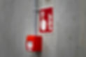 Red fire alarm and sign on a gray concrete wall