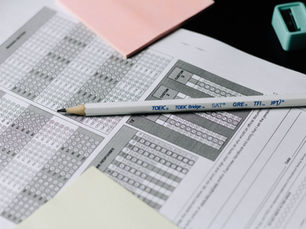 Pencil resting on outdated standardized test sheets, contrasted with bright modern elements — symbolizing the shift from old exams to future-ready assessments.