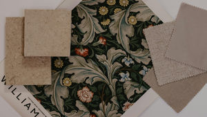 Flat lay of floral wallpaper and fabric swatches with beige sample cards and William Morris print text on a white background.