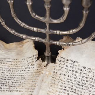 Jewish Menorah and ancient parchment scrolls on display during a Yad Vashem private tour.