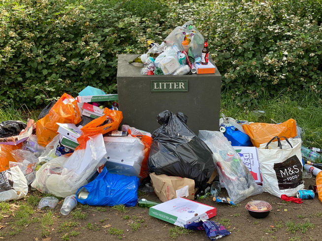 Overfilled litter bin overflowing with rubbish