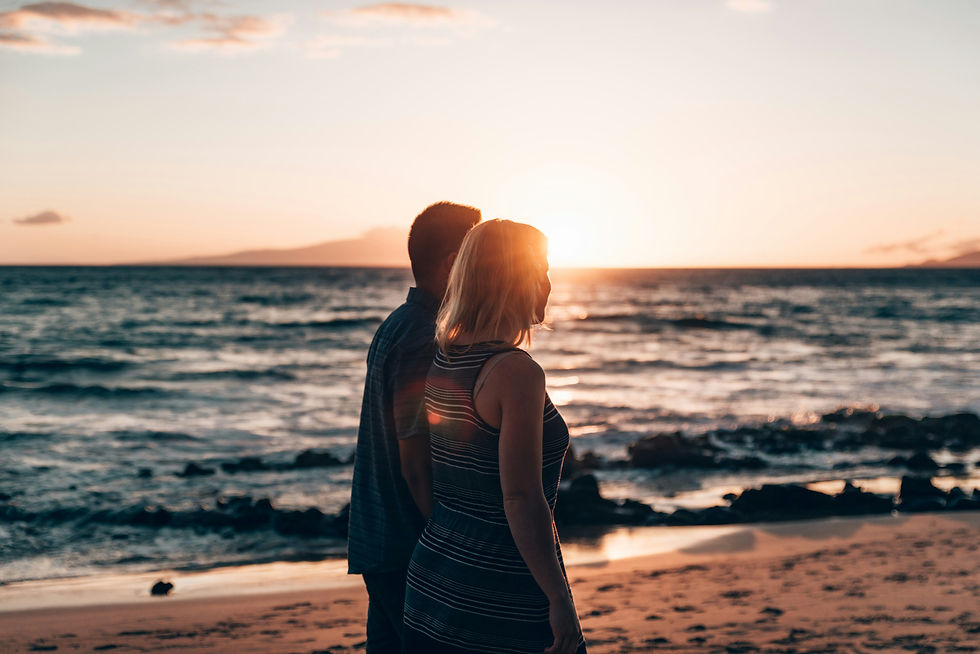 Couple on a beach in Maui at sunset on their Hawaii honeymoon