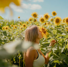 A woman in the middle of a sunflower field
