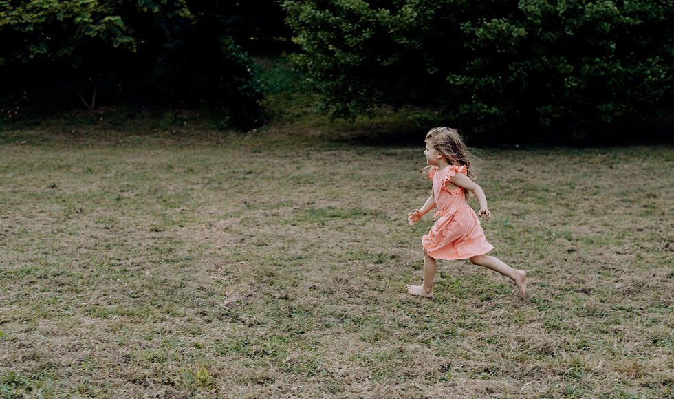Young girl running freely in a backyard, reflecting a child’s flight response and the need for safety, movement, and regulation.