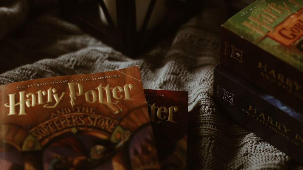 A cozy reading nook featuring beloved Harry Potter books, softly illuminated by the warm glow of a candle lantern.