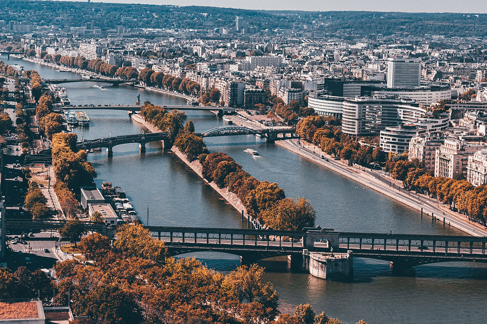 A stunning aerial view of Paris reveals the serene flow of the Seine River, lined with autumn trees and iconic architecture, showcasing the city's enchanting blend of nature and urban life.