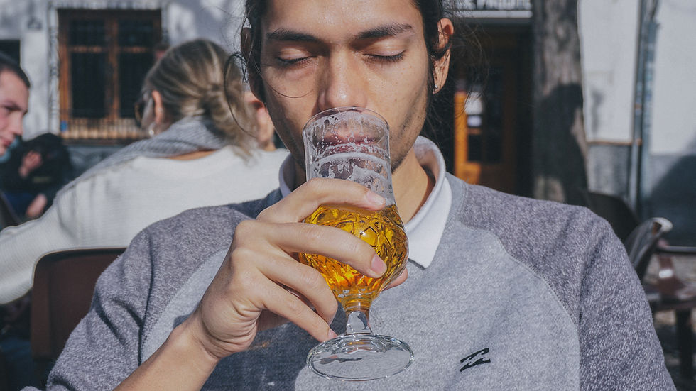 Man looking longingly at a glass of beer, suggesting alcohol craving or temptation