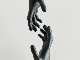 Two hands reaching toward each other with a small gap between them against a minimal background.
